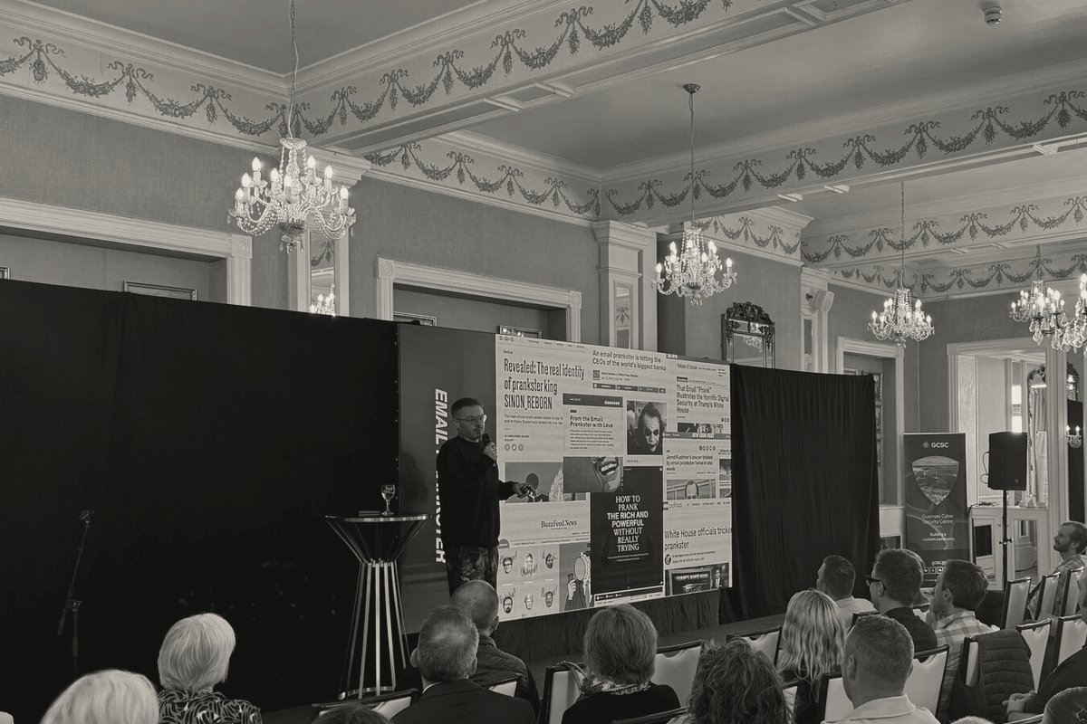 James Linton delivering a keynote, his press coverage on the screen behind him